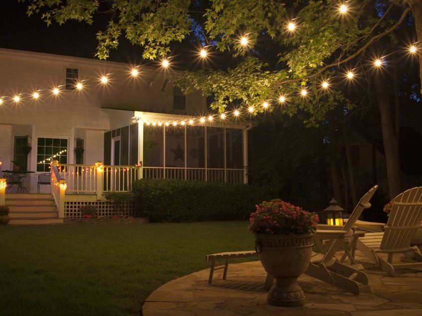 String lights stretched across a backyard at night