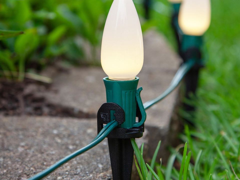 Warm white C9 bulbs on stakes lining a garden path