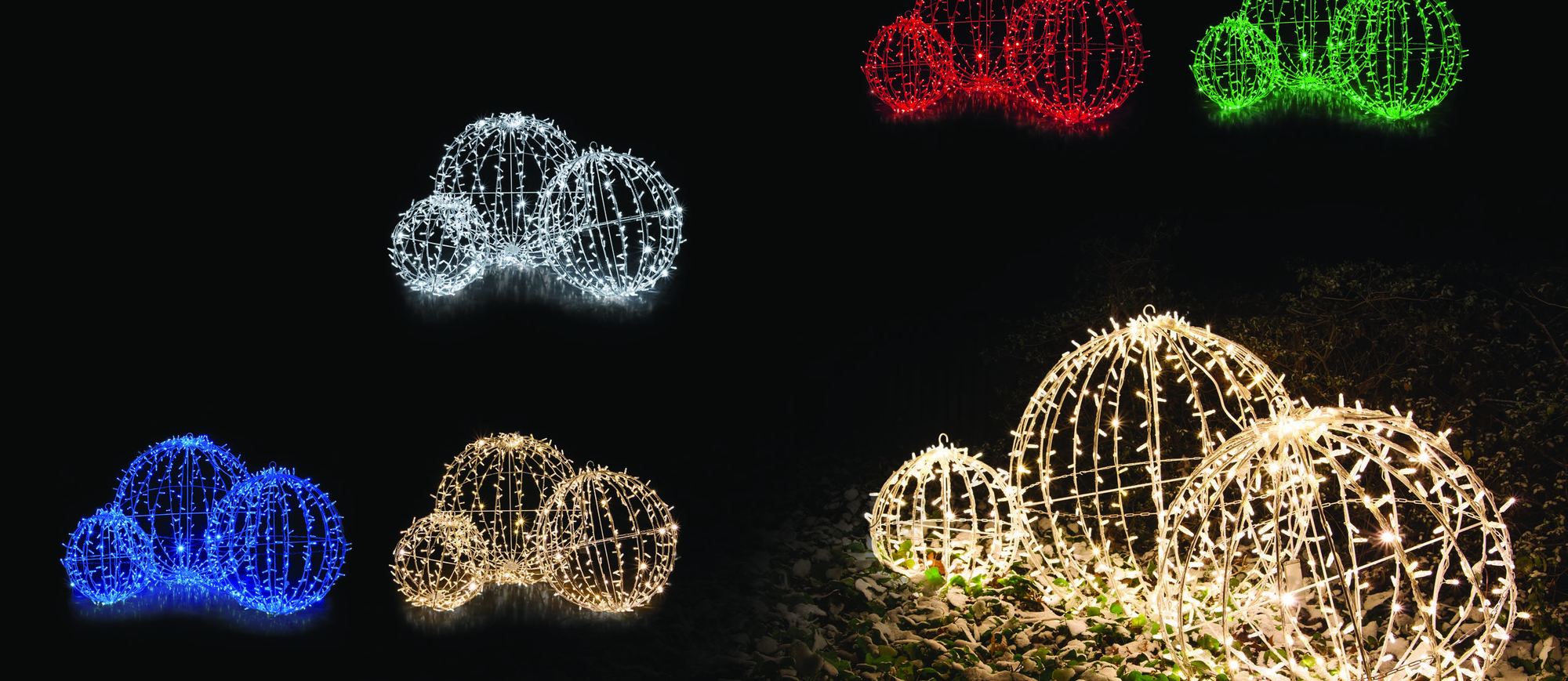 Groups of large lit spheres in warm white, red, green and blue on a dark lawn